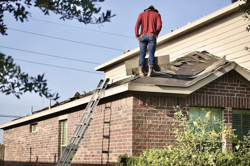 Professional roofer working on a residential roof in Wilgus